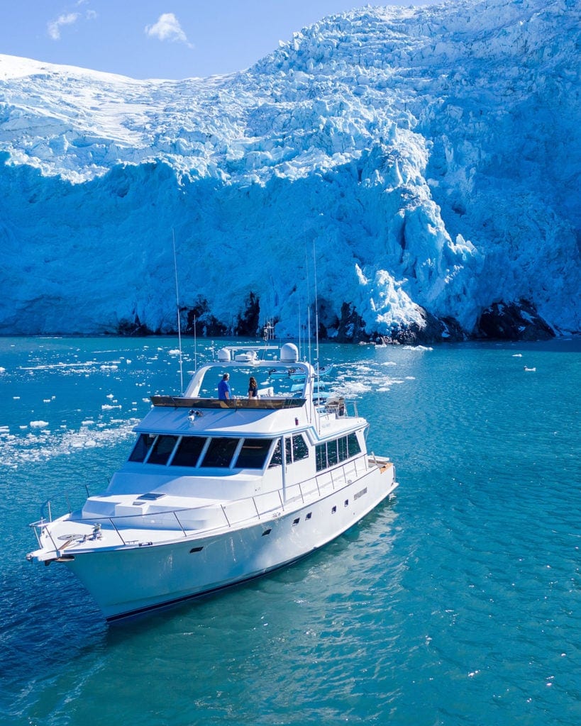 a small, luxury cruise ship in front of a tidewater glacier