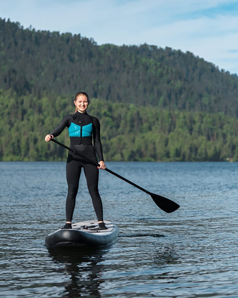a young woman on a paddle board in remote Alaskan waters